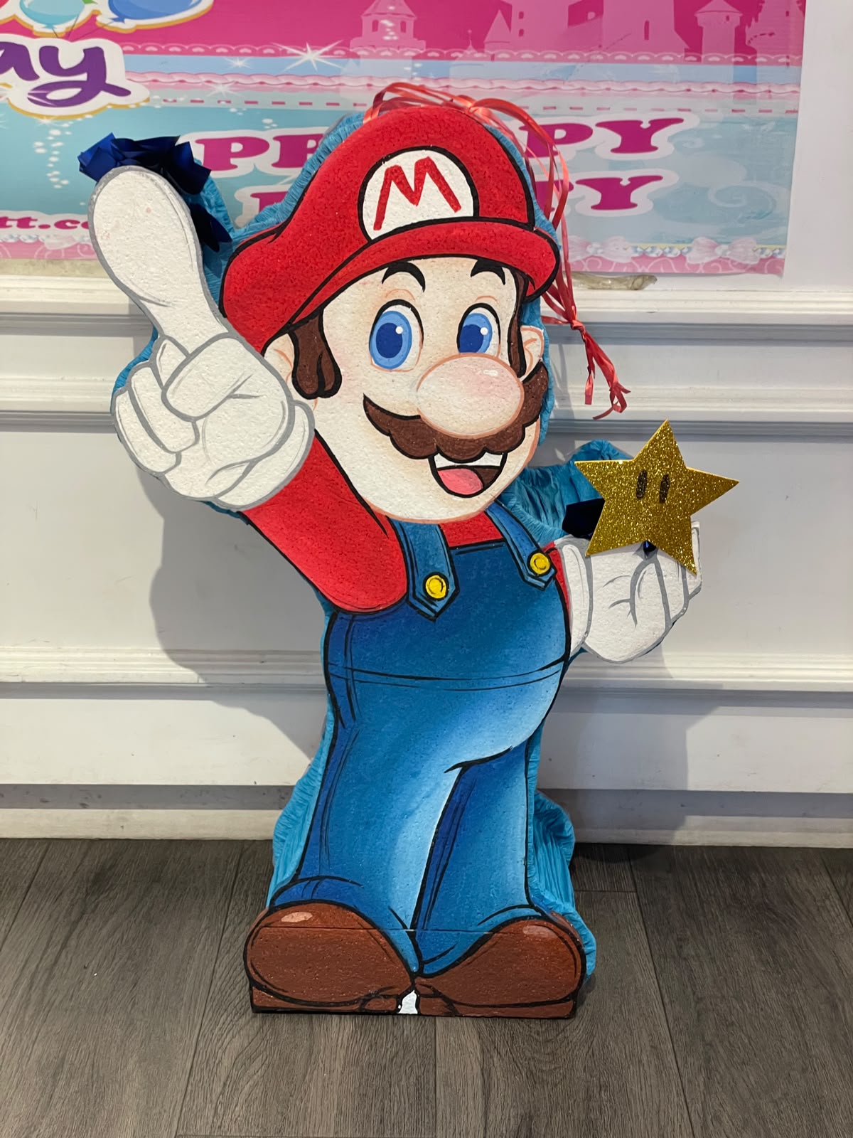 Super Mario holding a Super Star Pinata