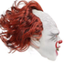 Side view of a pale Pennywise-inspired clown mask with crackled forehead detailing, red nose and swept-back auburn hair.